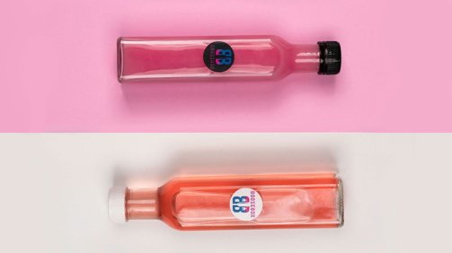 Four cocktail bottles with different colors of liquids on different colored backgrounds