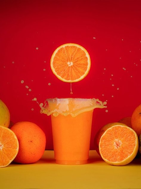 orange slice slashing inside orange juice cocktail around orange background