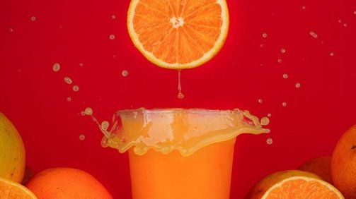 orange slice slashing inside orange juice cocktail around orange background
