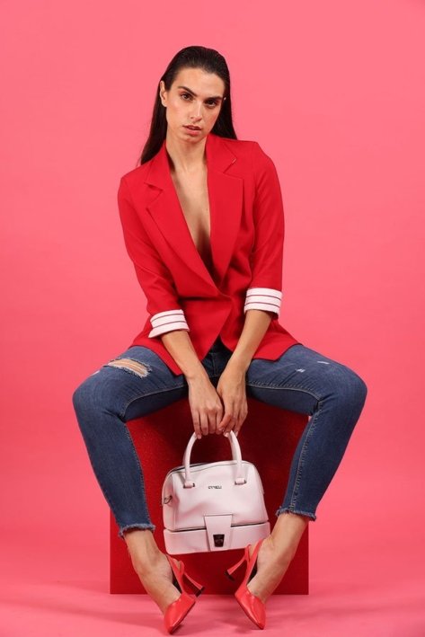 Young Woman Model wearing a red shirt and blue jeans and carrying a pink bag