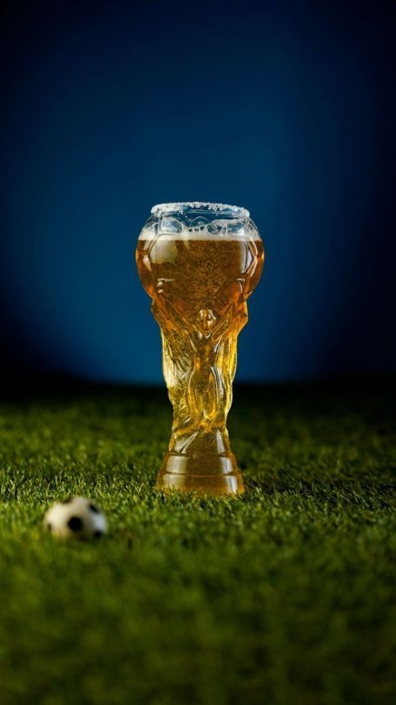 Beer Submarine cocktail inside world cup trophy cocktail glass placed on a green field