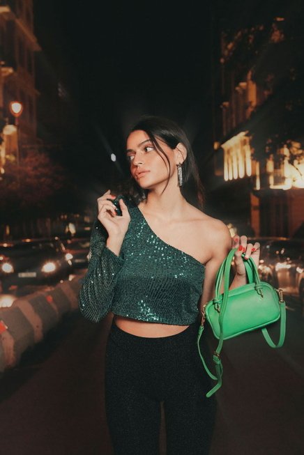 Young Woman Model In the Streets Wearing Sparkly Green Shirt and carrying green bag