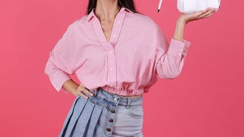 Young Woman Model wearing a pink shirt and jeans skrit and carrying a white bag