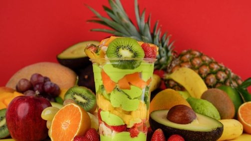 Avocado mixed cocktail around fruits background