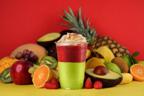 Red and Green layered fruit cocktail around fruits background