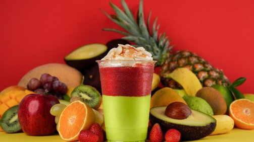 Red and Green layered fruit cocktail around fruits background
