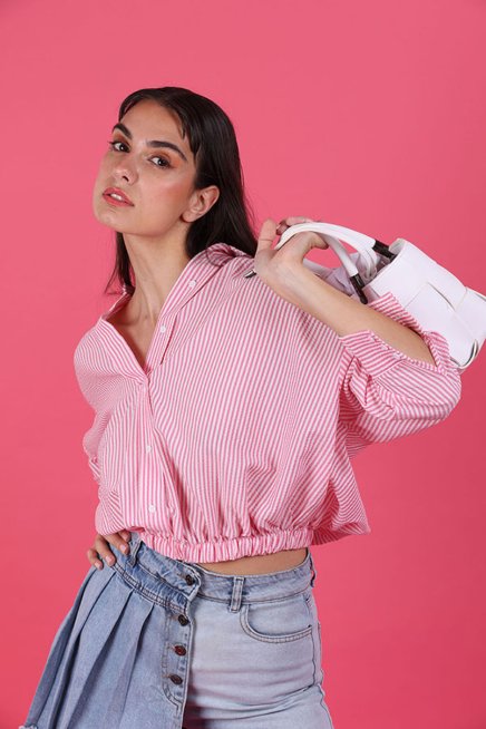 Young Woman Model Wearing Pink Shirt and Blue Jeans and carrying a white bag