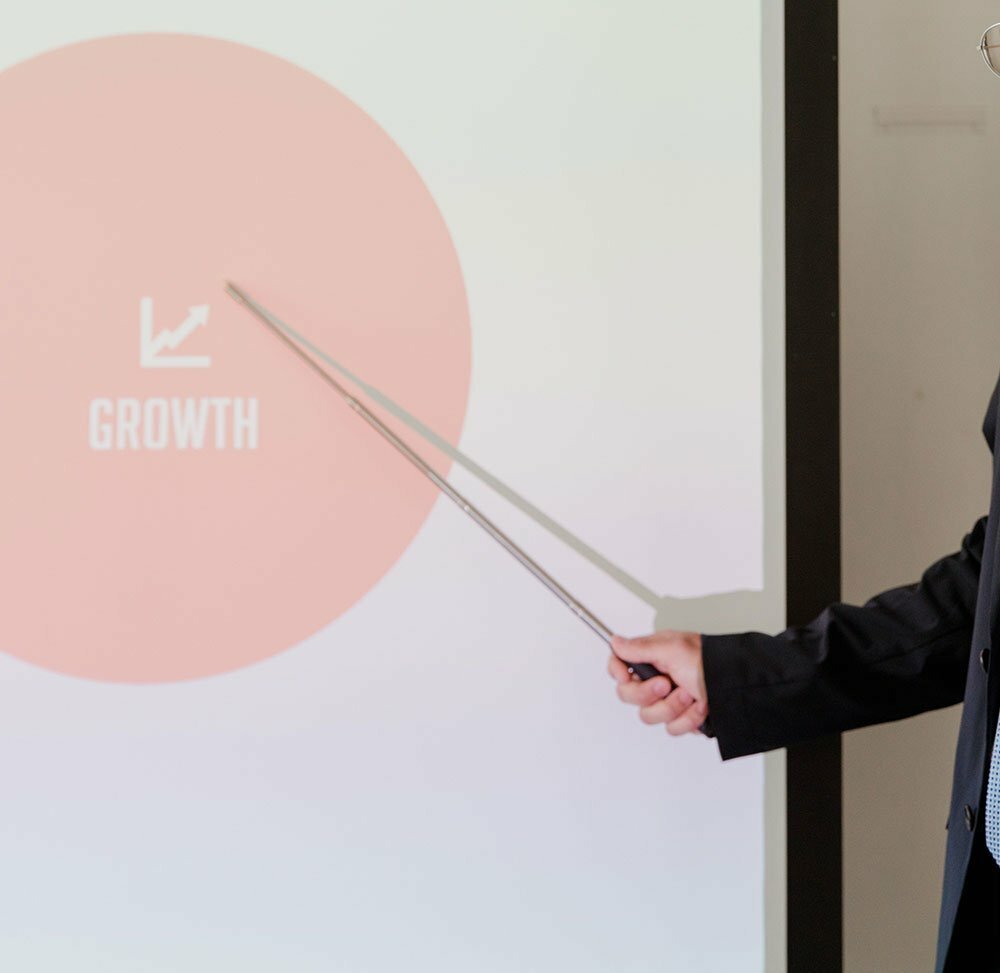 Businessperson pointing at the word growth on a white board